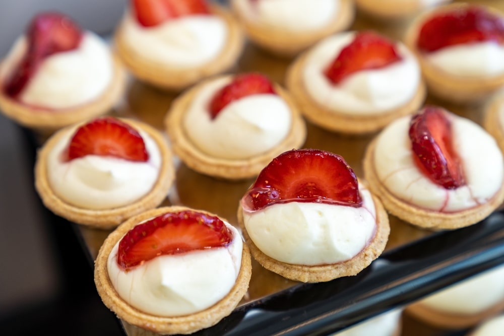 Corporate team members learning cocktail mixing during professional mixology workshop. Connect with earthy Gourmet for more fun.